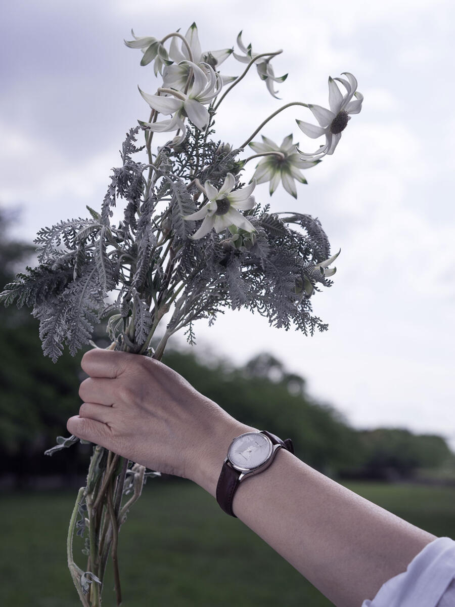 女性が花束を空に掲げる姿